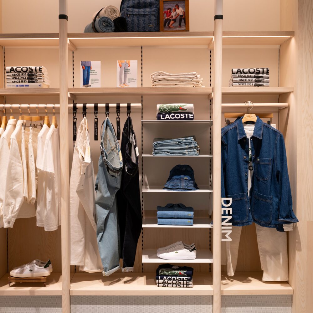 Section of Lacoste Flagship Store, Fifth Avenue, New York, displaying blazers, suits, and well-organized clothing illuminated by Zeplinn’s architectural lighting.