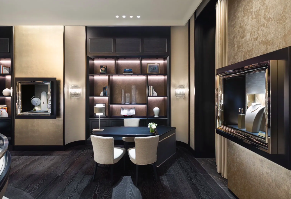 Seating area inside Van Cleef & Arpels boutique at Siam Paragon, Bangkok, with customers interacting with staff and illuminated wooden shelves by Zeplinn.