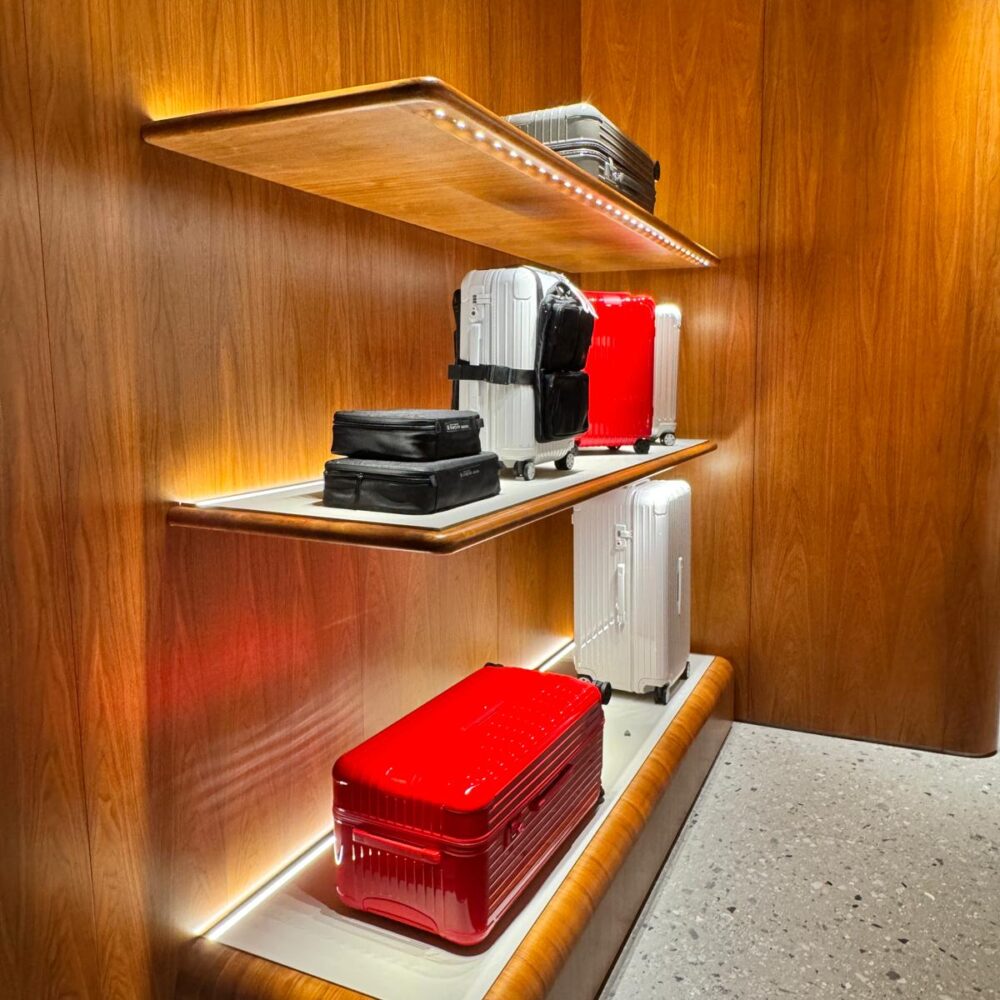 Wooden retail corner at RIMOWA New York store with Zeplinn architectural lighting illuminating luggage displays