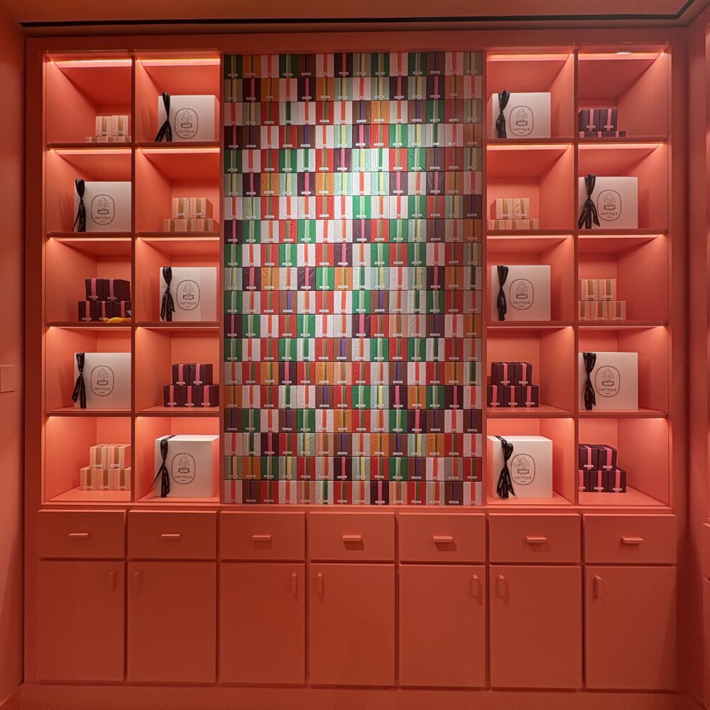 Candles displayed on shelves at Diptyque Miami Brickell under Zeplinn architectural lighting