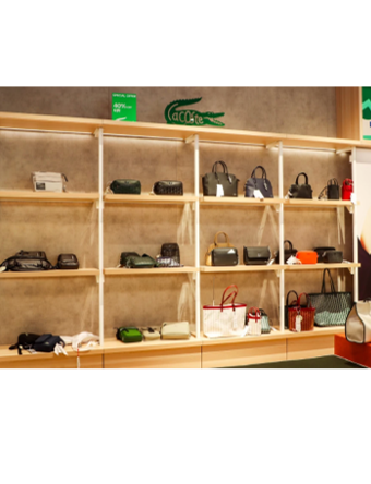 Lacoste Miami bags displayed on shelves under Zeplinn architectural lighting
