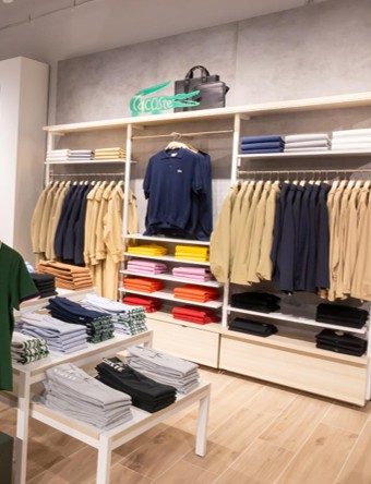 Clothing displayed on racks in Lacoste Miami store, enhanced by Zeplinn architectural lighting