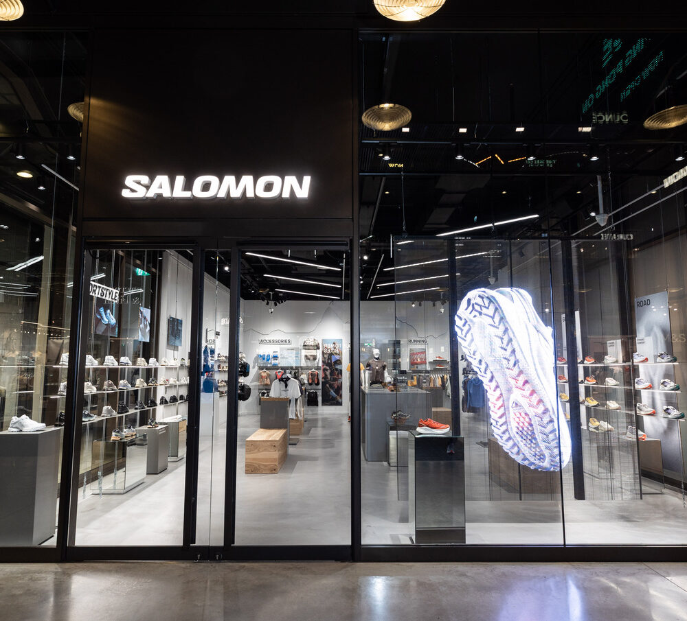 Entrance of Salomon Battersea store illuminated by Zeplinn fixtures, with a holographic shoe display and precision 4000K CRI95 lighting.